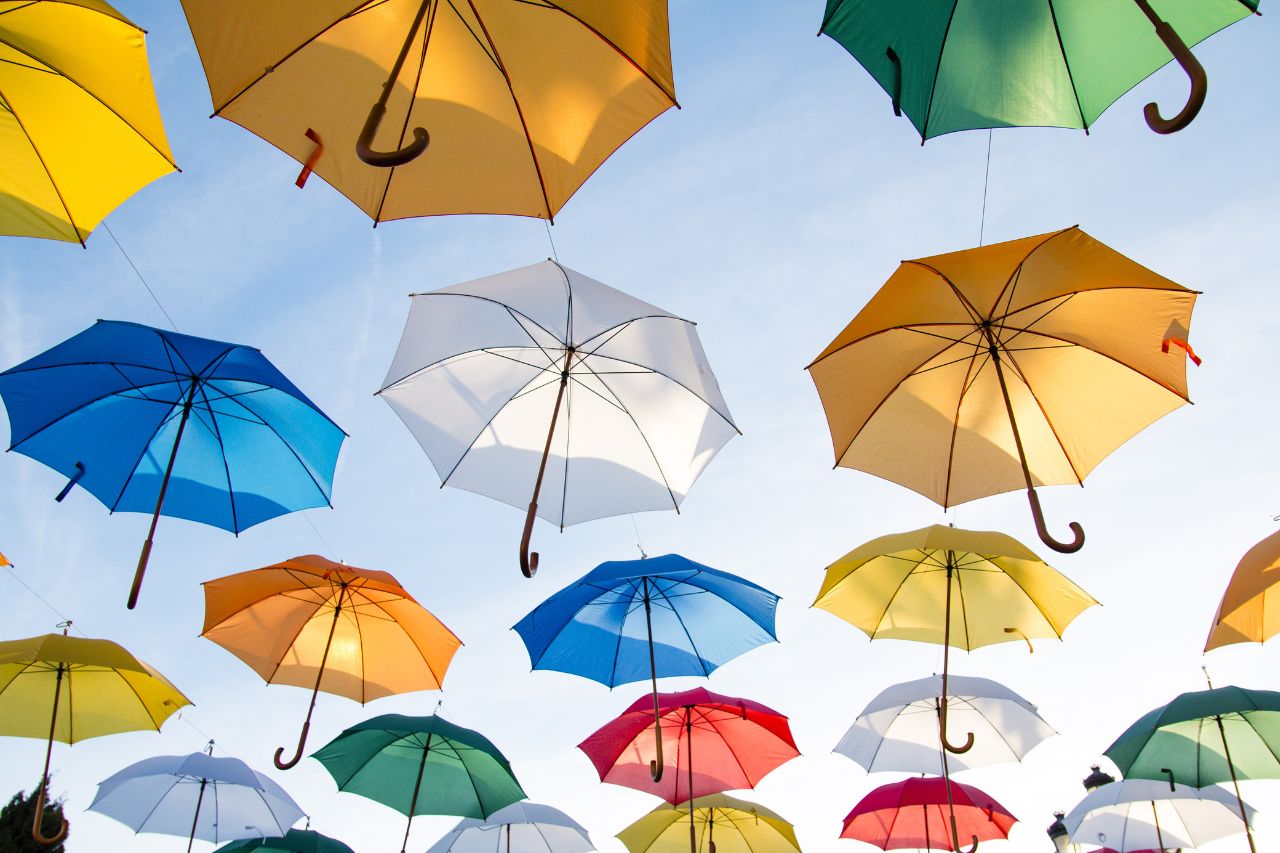 Kuvapankki kuva erivärisiä sateenvarjoja taivaalla.