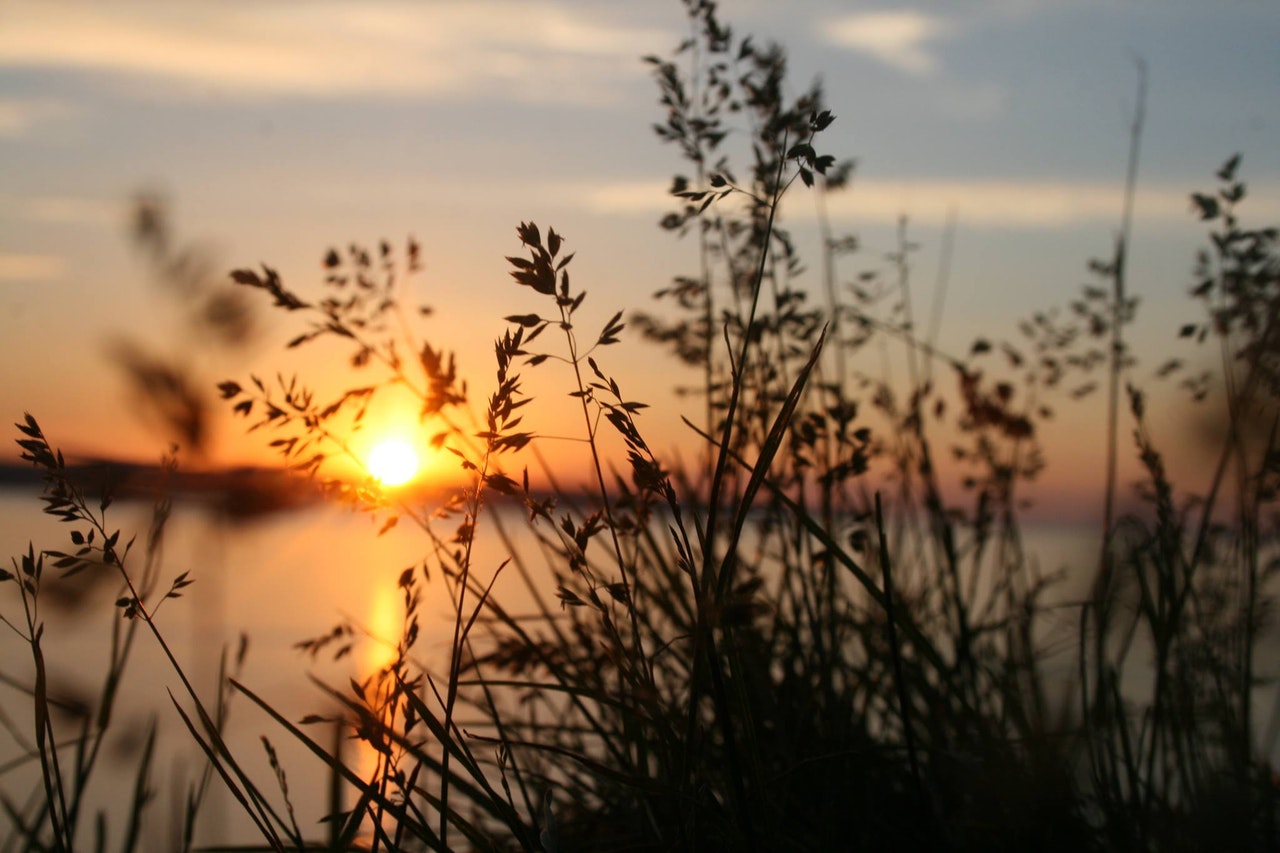 Kuvapankkikuva auringonlasku järvelle.